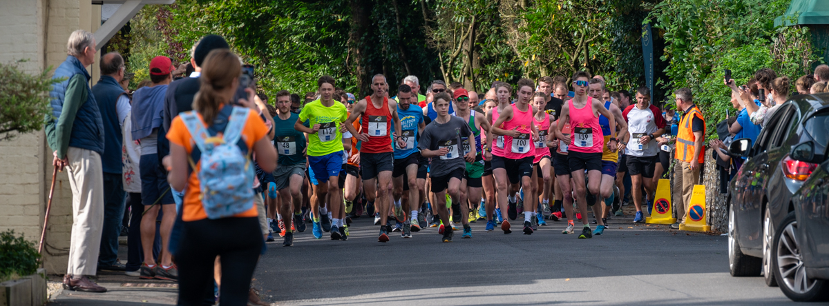 Runners on the trail at the Hambledon Hilly, with the vineyard in the background